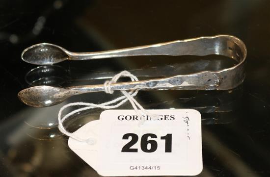 A pair of 1930s planished silver sugar tongs by Omar Ramsden, 25 grams.